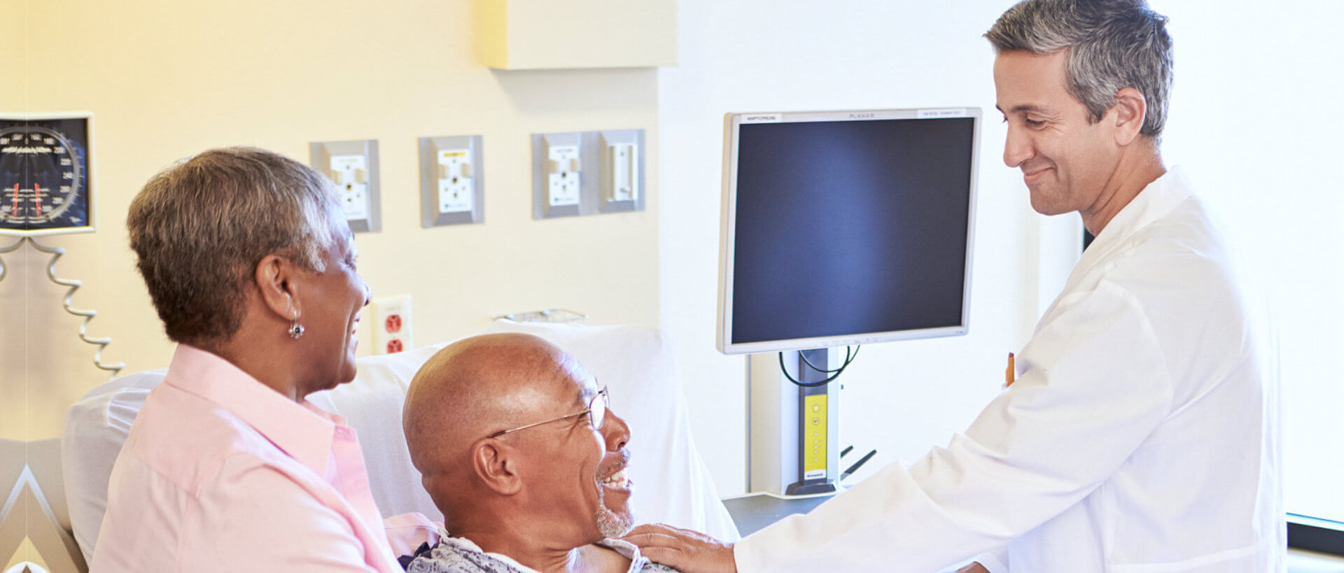 happy senior couple talking to doctor